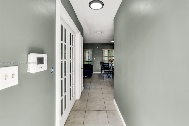 hall with french doors and light tile patterned floors