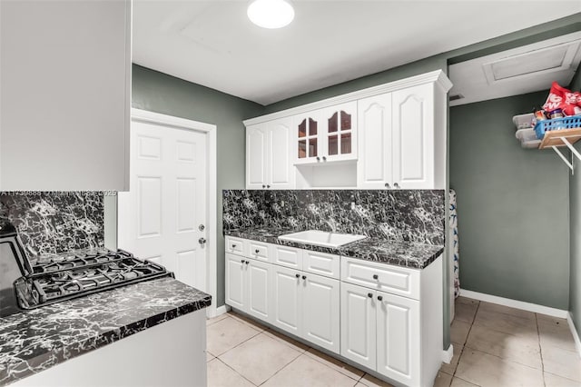 kitchen featuring white cabinetry, sink, light tile patterned floors, and backsplash