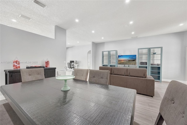 dining area featuring a textured ceiling and light wood-type flooring