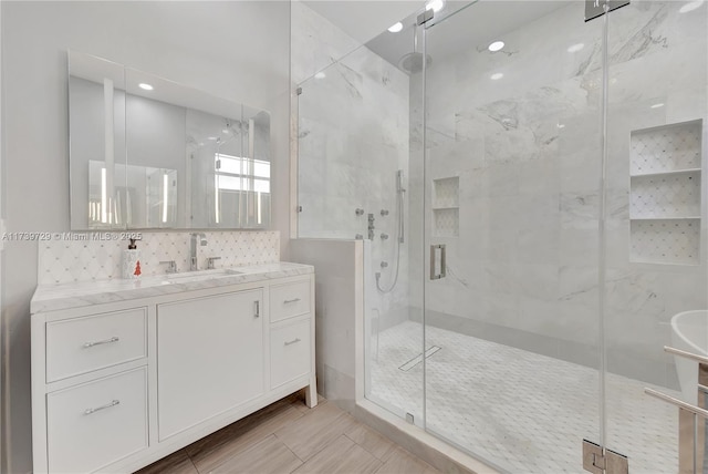 bathroom with vanity, decorative backsplash, and a shower with shower door