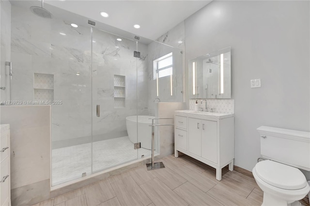 bathroom with tasteful backsplash, vanity, toilet, and a shower with door