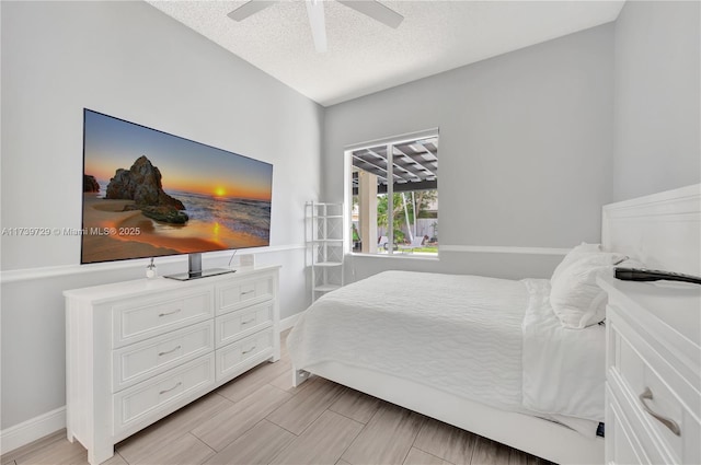 bedroom with ceiling fan and a textured ceiling