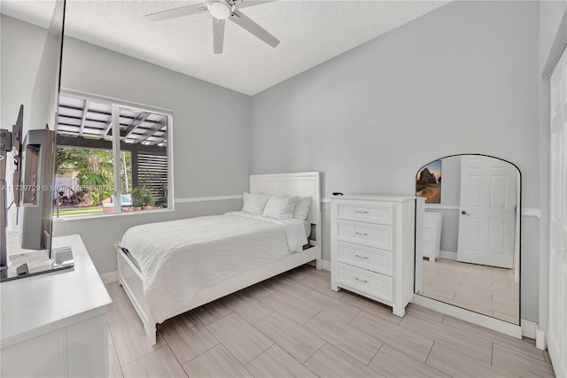 bedroom with ceiling fan and a textured ceiling