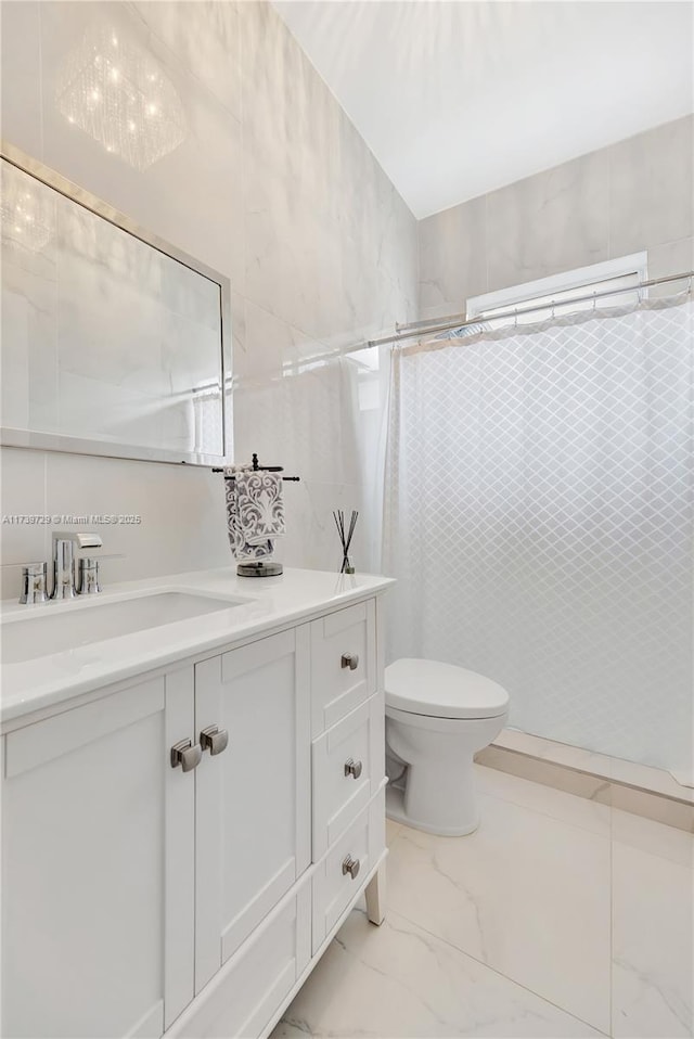 bathroom featuring vanity, toilet, a shower with shower curtain, and tile walls