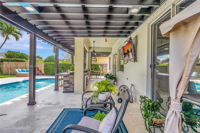 view of patio with ceiling fan and a bar