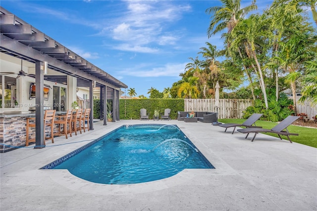 view of swimming pool featuring a bar, a patio area, outdoor lounge area, and pool water feature