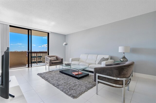 tiled living room with a textured ceiling and a wall of windows