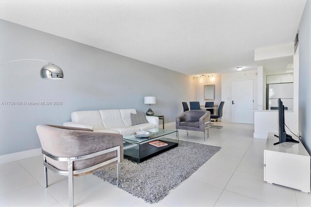 tiled living room featuring a textured ceiling