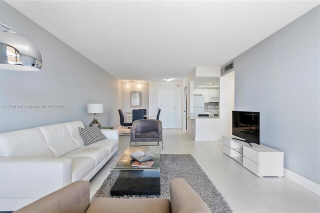 living room with light tile patterned flooring and a textured ceiling