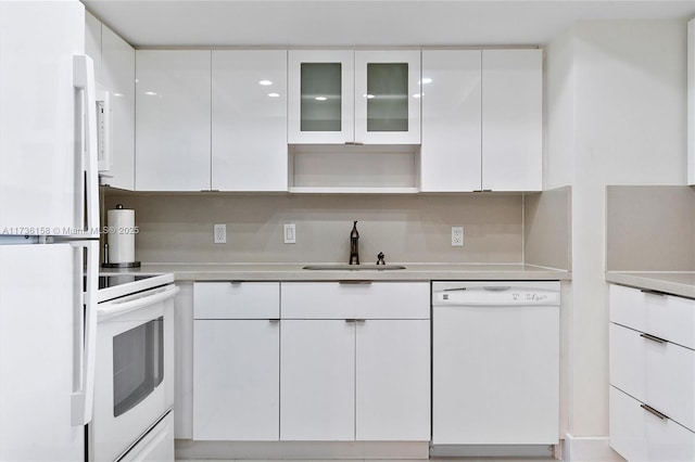 kitchen featuring white cabinetry, white appliances, sink, and decorative backsplash