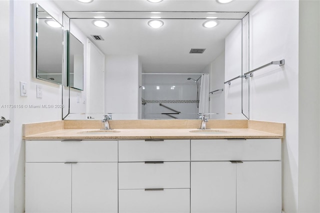 bathroom featuring tiled shower and vanity