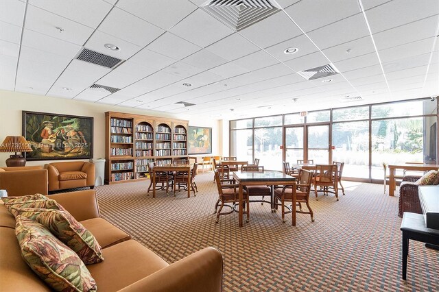 carpeted dining room with a wall of windows