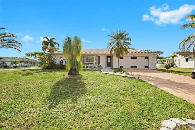 ranch-style house featuring a tile roof, a front lawn, stucco siding, concrete driveway, and an attached garage