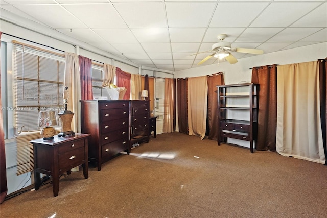 carpeted bedroom featuring a drop ceiling