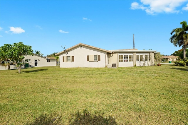 rear view of house featuring a lawn