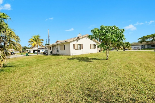 rear view of property with stucco siding and a yard