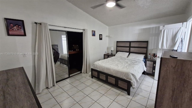 bedroom with light tile patterned floors, vaulted ceiling, a textured ceiling, and ceiling fan