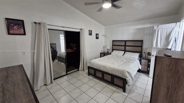 bedroom with lofted ceiling, light tile patterned floors, a textured ceiling, and ceiling fan