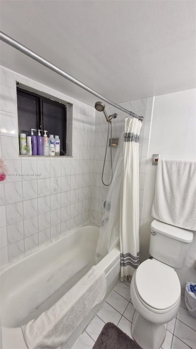 bathroom with a textured ceiling, toilet, and shower / bath combo with shower curtain