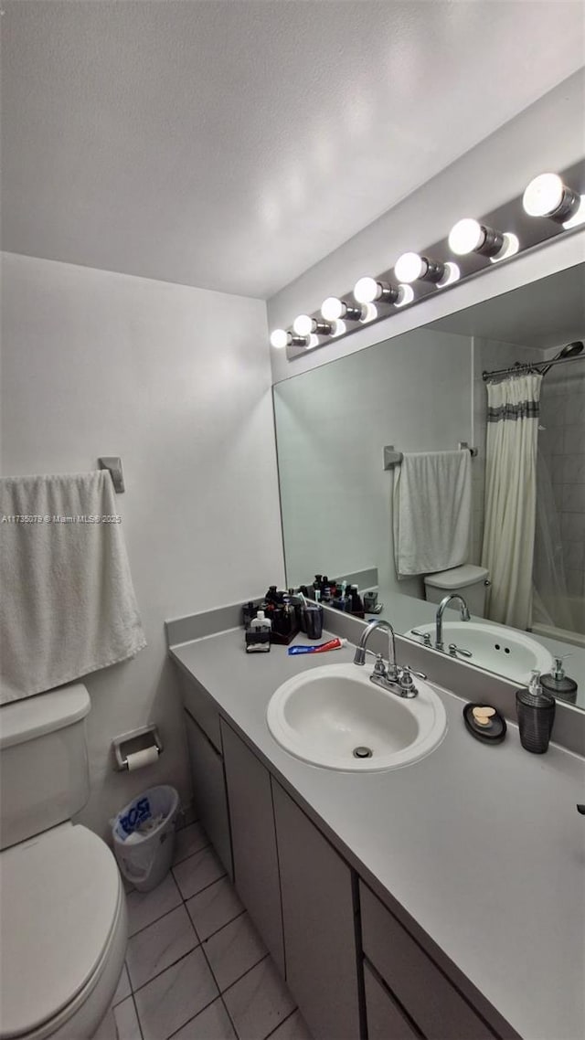 bathroom with a shower with shower curtain, vanity, a textured ceiling, tile patterned floors, and toilet