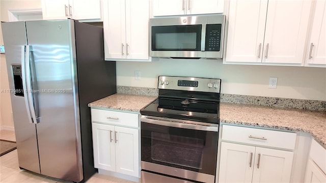 kitchen with appliances with stainless steel finishes, white cabinetry, and light stone countertops