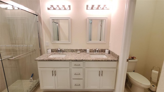 bathroom with a sink, toilet, and a shower stall