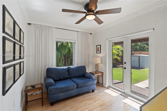 sitting room featuring ornamental molding, french doors, a healthy amount of sunlight, and light wood-style floors