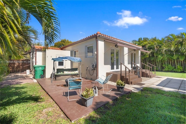 back of house with french doors, fence, a yard, a patio area, and an outdoor structure