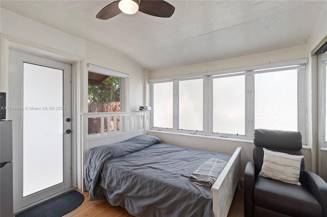 bedroom featuring a textured ceiling, a ceiling fan, and wood finished floors