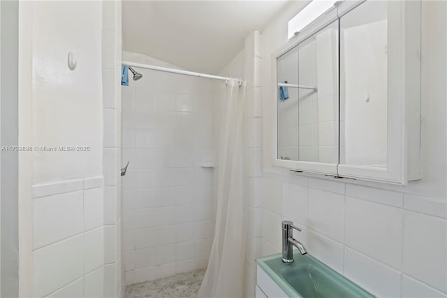 full bathroom featuring a tile shower and tile walls