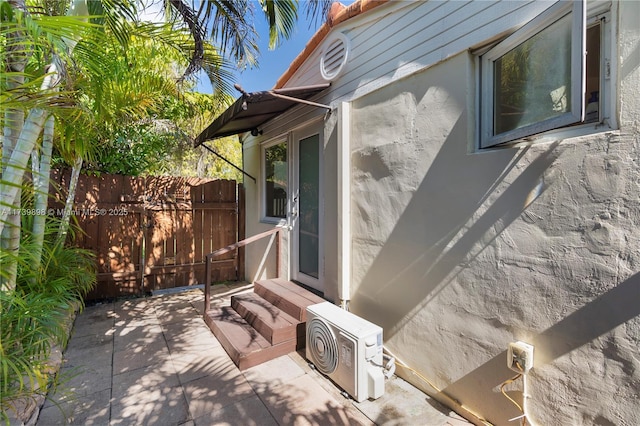 view of home's exterior featuring ac unit, stucco siding, entry steps, a patio area, and fence