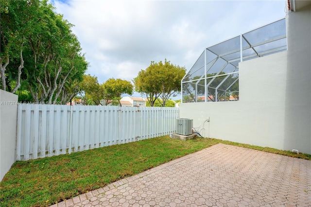 view of yard with cooling unit, a lanai, and a patio