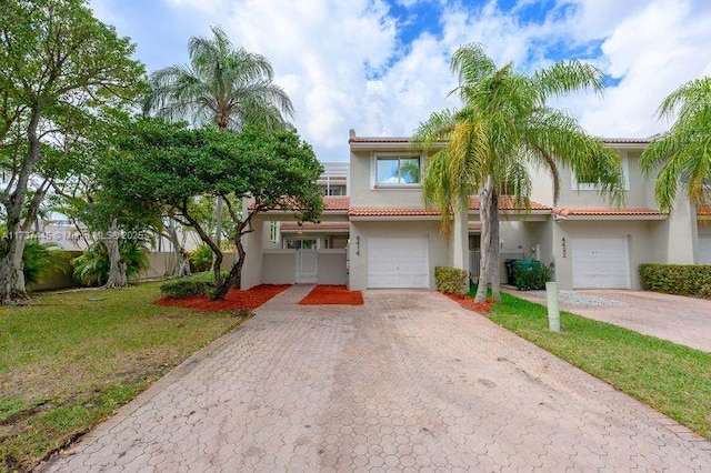 mediterranean / spanish house with a garage and a front lawn