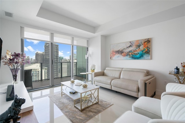 tiled living room with a wall of windows and a raised ceiling