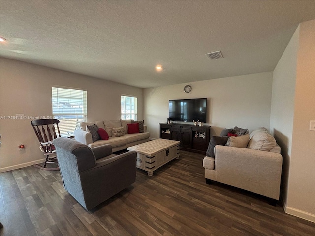 living room with a textured ceiling and dark hardwood / wood-style flooring