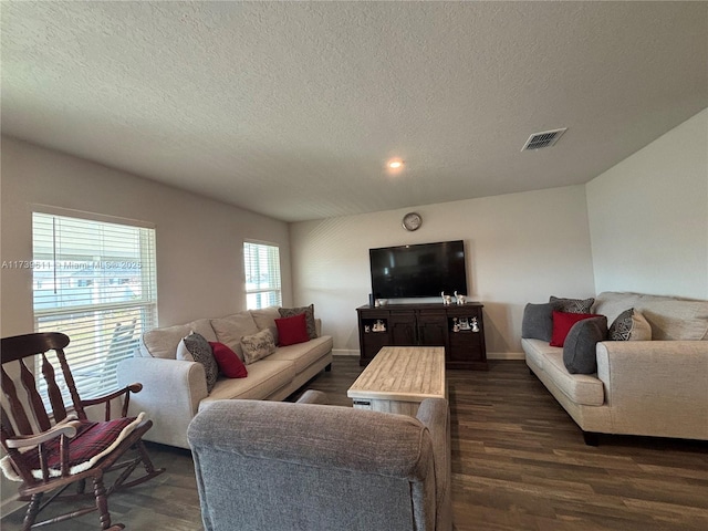 living room featuring dark wood-type flooring and a textured ceiling