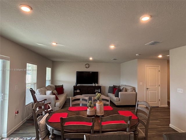 dining space featuring dark hardwood / wood-style flooring and a textured ceiling