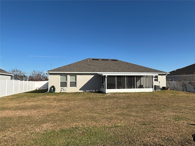 rear view of property featuring central AC, a yard, and a sunroom