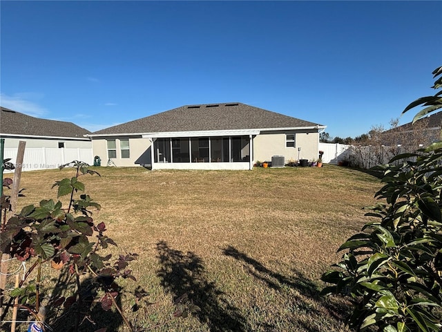 rear view of property featuring a sunroom, central AC unit, and a lawn