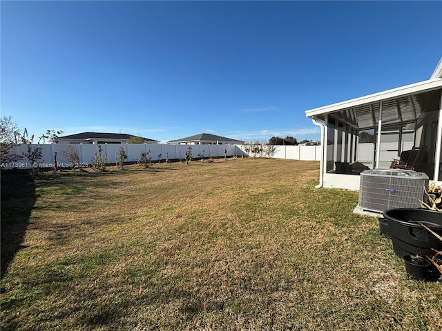 view of yard featuring a sunroom and central air condition unit