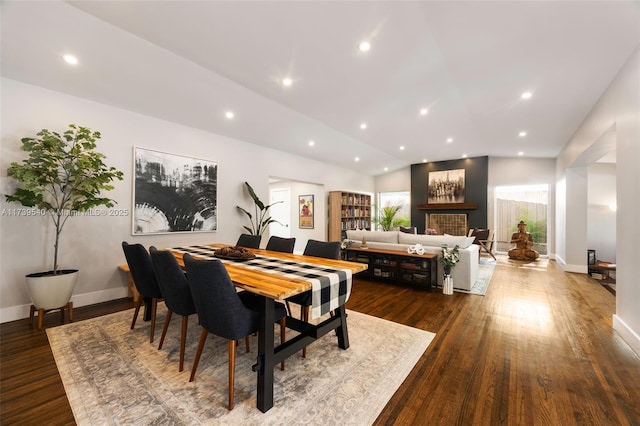 dining space with dark wood-type flooring and vaulted ceiling