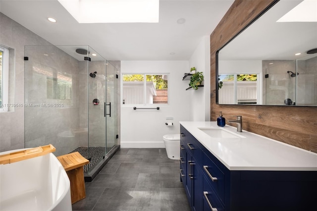 bathroom featuring a healthy amount of sunlight, toilet, a skylight, and vanity