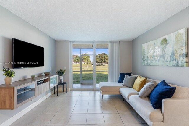 living room featuring floor to ceiling windows, light tile patterned floors, and a textured ceiling