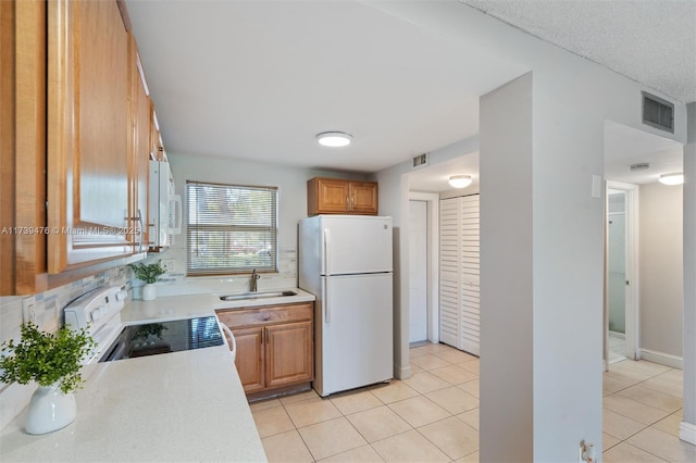 kitchen featuring sink, white appliances, and light tile patterned floors