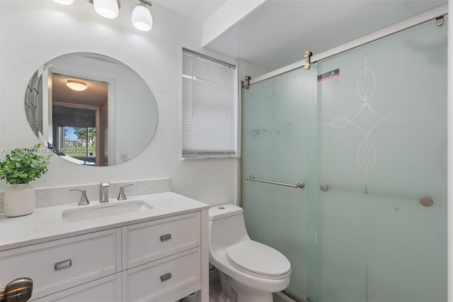 bathroom featuring an enclosed shower, vanity, and toilet