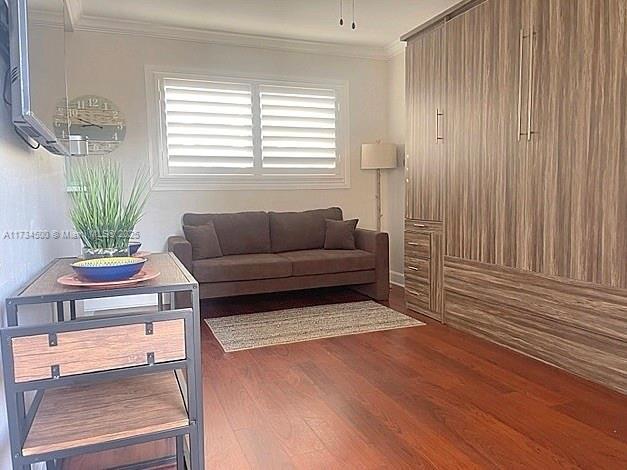 living room featuring crown molding and dark hardwood / wood-style floors