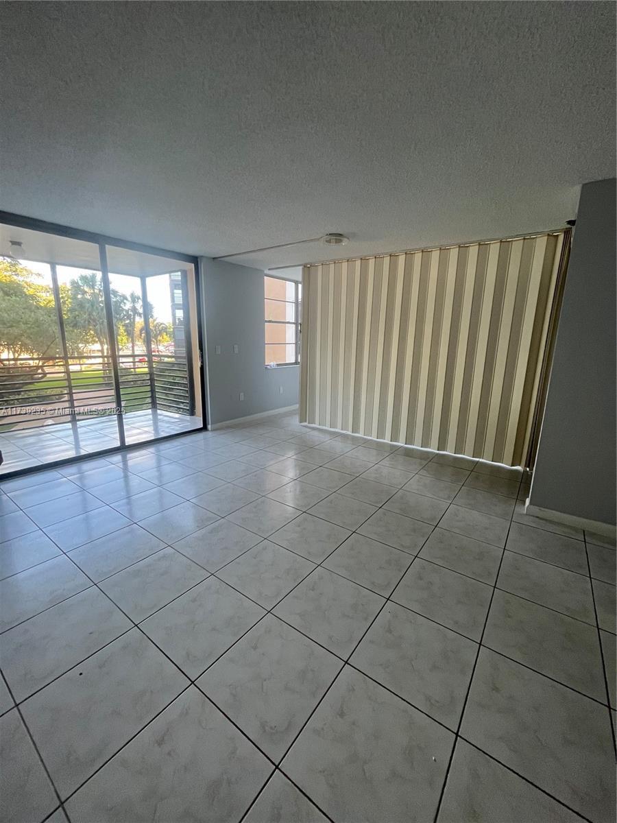 spare room with light tile patterned floors and a textured ceiling