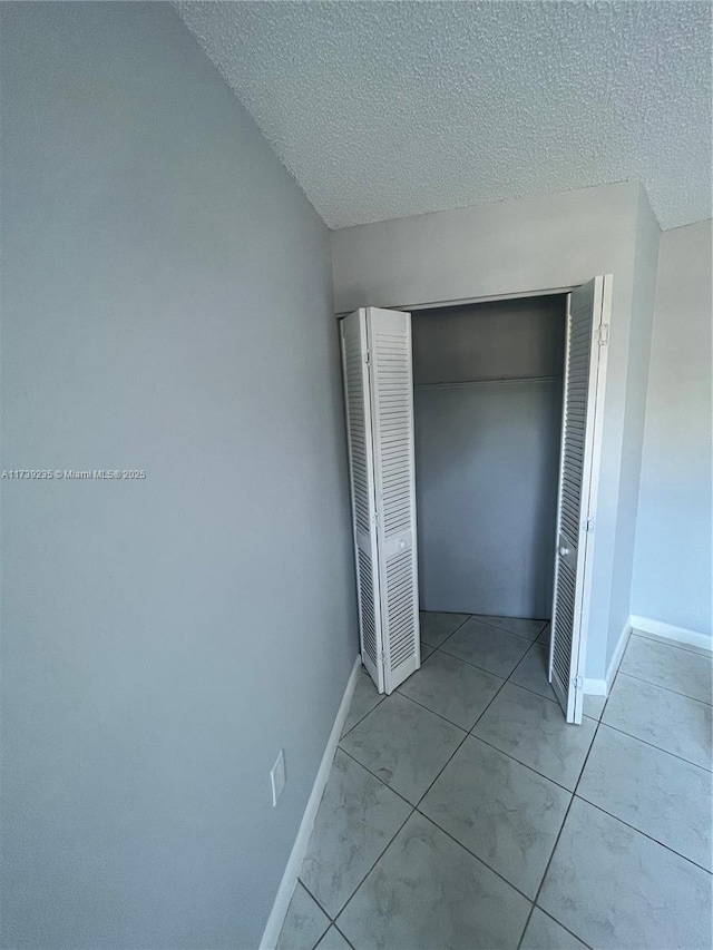 unfurnished bedroom with a closet and a textured ceiling