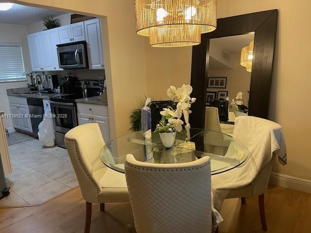 dining space featuring an inviting chandelier and light hardwood / wood-style floors