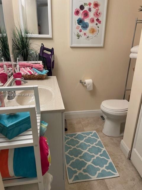 bathroom featuring vanity, tile patterned floors, and toilet